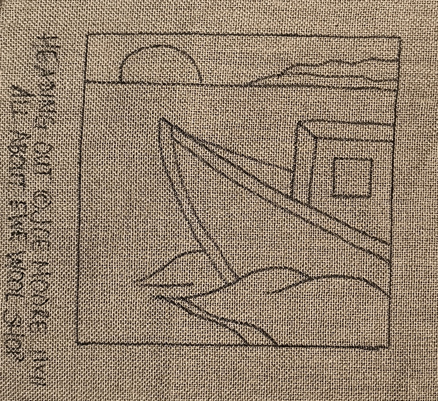 a close up of a piece of cloth with a drawing of a boat