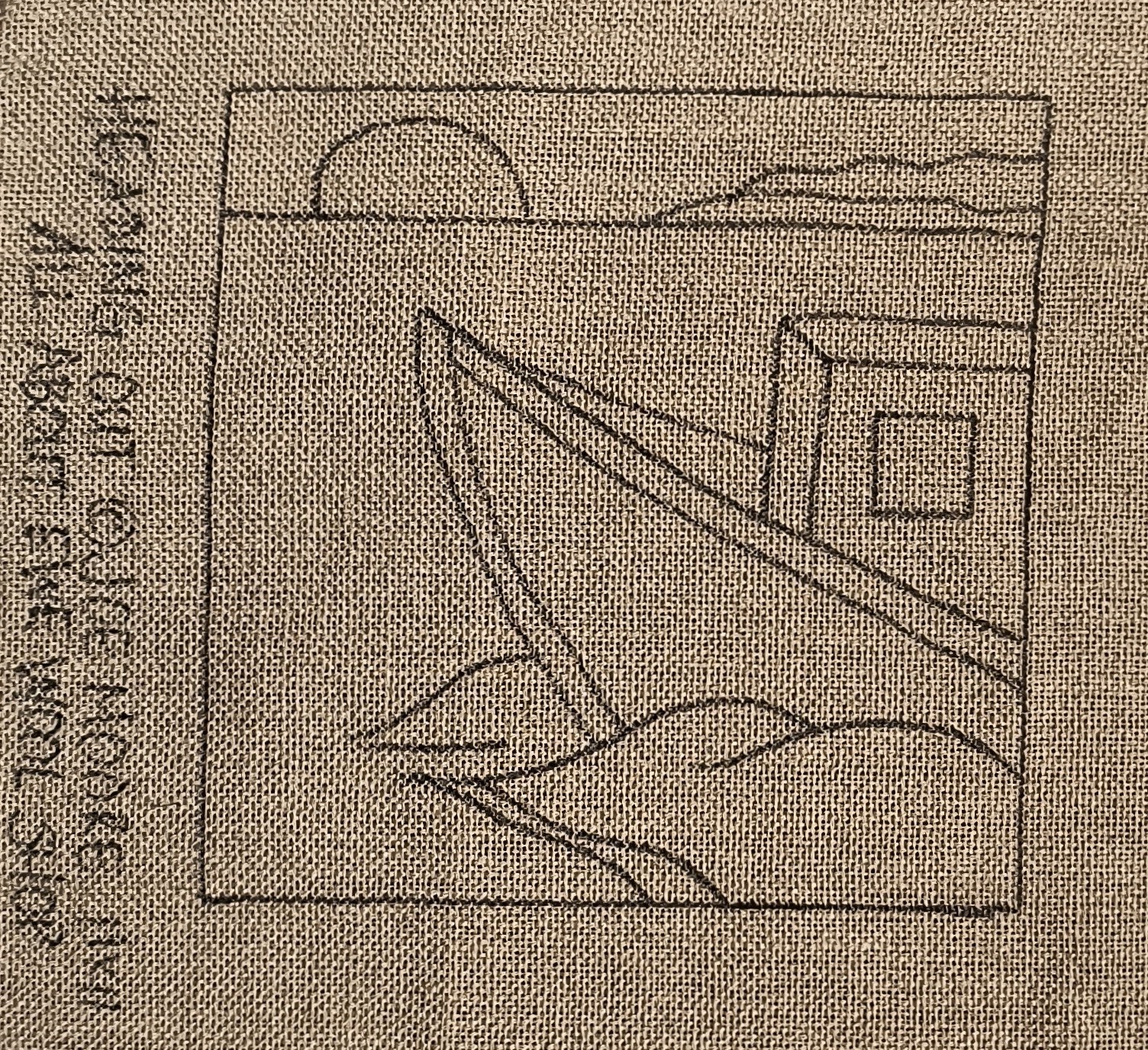 a close up of a piece of cloth with a drawing of a boat